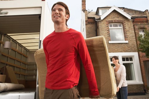 Movers carrying boxes in a narrow flat entrance